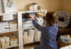 une femme rangeant ses étagères et réorganisant ses affaires : méthode konmari de Marie Kondo
