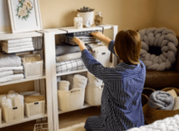 une femme rangeant ses étagères et réorganisant ses affaires : méthode konmari de Marie Kondo